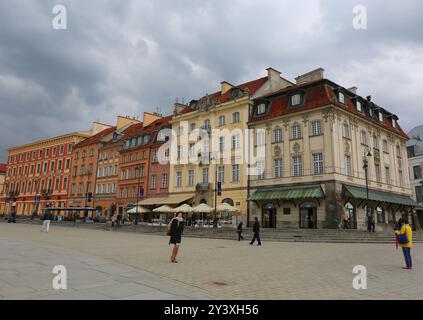 WARSCHAU, POLEN - 15. MAI 2015: Unbekannte Menschen gehen an den farbenfrohen alten Gebäuden in der Altstadt in der Nähe des Schlossplatzes vorbei Stockfoto