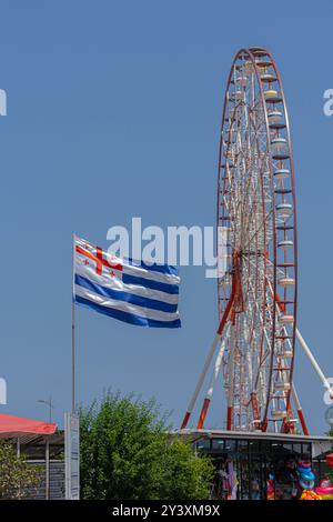 Flagge von Adjara auf dem Hintergrund des Riesenrades. BATUMI, GEORGIA, 15. Juli 2024 Stockfoto