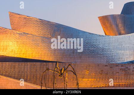 Die große Spinne vor dem berühmten Guggenheim Museum in der spanischen Stadt Bilbao mit ihren markanten Formen und Silber- und goldfarbenen glänzenden Ex Stockfoto
