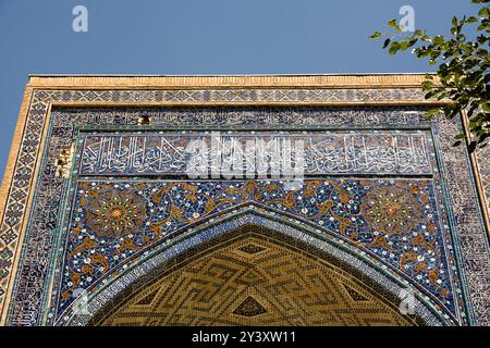 Detail mit arabischen Schriften aus dem Koran am Eingangsportal zu einer Madrassa im Registan in Samarkand Stockfoto