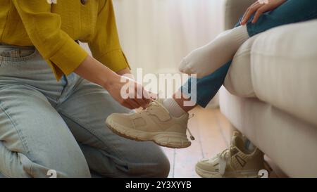 Unerkennbare liebender kaukasischer Frau Mutter Pfleger weibliche Hände Schnürsenkel Schnürsenkel unbekannte kleine Mädchen Tochter hilft Sneakers Kind hineinzubinden Stockfoto