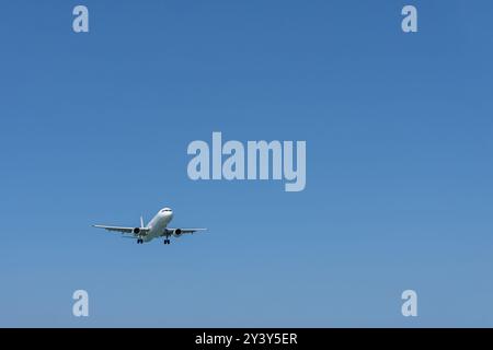 Ein sich näherndes Flugzeug am leeren blauen Himmel. Stockfoto