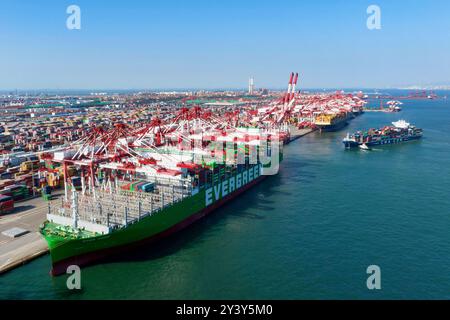 QINGDAO, CHINA - 15. SEPTEMBER 2024 - AEON, das weltweit größte Schiff nach Containervolumen, lädt Container am Liegeplatz 81 des Qianwan Container Termi Stockfoto