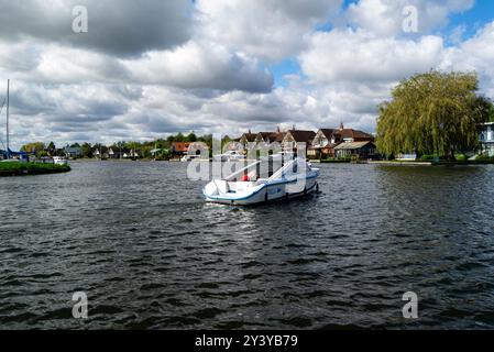 Motorboot Segeln entlang des Flusses Bure durch das attraktive Dorf Horning Norfolk Broads England Großbritannien Stockfoto