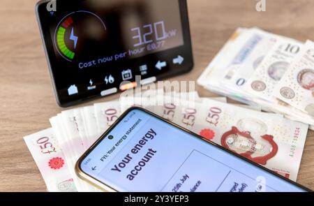 Ein Konzept für Energieverbrauch und Kosten mit digitaler Rechnung auf einem Mobiltelefon, intelligentem Energiemesser und Banknoten. Stockfoto