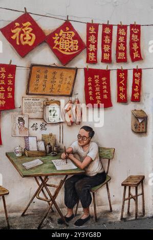 Ein gemaltes Wandgemälde des singapurischen Künstlers Yip Yew Chong mit hängenden chinesischen Briefen und einem chinesischen Schriftsteller in der Smith Street, Chinatown, einem alten historischen C Stockfoto