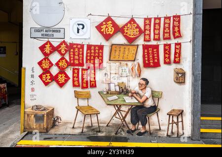 Ein gemaltes Wandgemälde des singapurischen Künstlers Yip Yew Chong mit hängenden chinesischen Briefen und einem chinesischen Schriftsteller in der Smith Street, Chinatown, einem alten historischen C Stockfoto