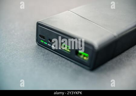 Eine detaillierte Ansicht einer tragbaren Powerbank mit USB-C- und USB-Anschlüssen mit beleuchteten Anzeigen, ideal zum Laden von Smartphones und anderen Elektronen Stockfoto