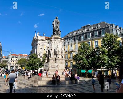 Menschen, die durch die Prac Luís de Camões laufen, ein historisches Wahrzeichen in Lissabon, Portugal. Stockfoto