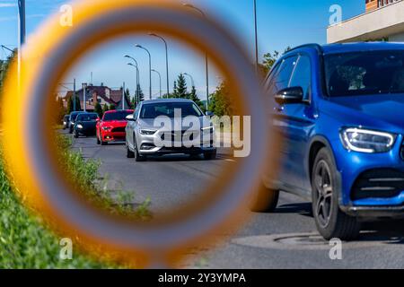 Verkehrsunfall auf den Fahrspuren neben einem markierten Fußgängerübergang zur Schule, beschädigtes Verkehrsschild, reflektierende Figur, die vor dem Fußgängerübergang warnt Stockfoto