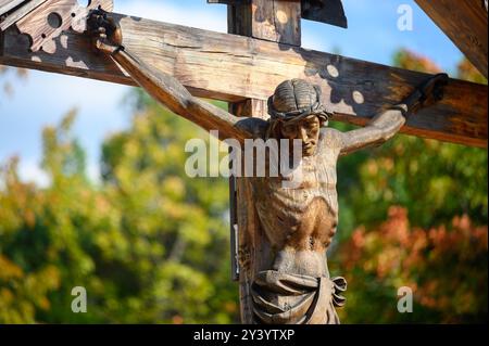 Ein hölzerner gekreuzigter Jesus auf dem Berg Podbrdo, dem Anblick auf das Dorf Medjugorje in Bosnien und Herzegowina. Stockfoto