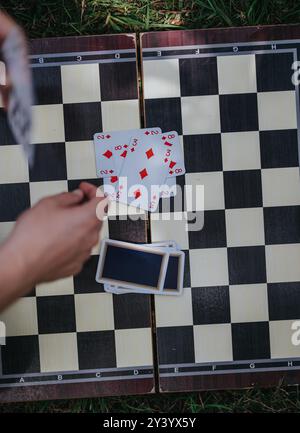 Kartenspiel auf einem Schachbrett im Freien in einer Sommeratmosphäre Stockfoto