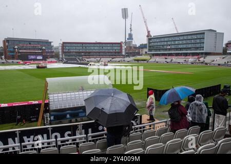 Ein allgemeiner Blick auf das Innere von Old Trafford, während Fans sich vor dem dritten Spiel der Vitality IT20 Series England gegen Australien in Old Trafford, Manchester, Großbritannien, 15. September 2024 unter Regenschirmen in Deckung nehmen (Foto: Gareth Evans/News Images) Stockfoto