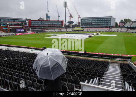 Ein allgemeiner Blick auf das Innere von Old Trafford, während Fans sich vor dem dritten Spiel der Vitality IT20 Series England gegen Australien in Old Trafford, Manchester, Großbritannien, 15. September 2024 unter Regenschirmen in Deckung nehmen (Foto: Gareth Evans/News Images) Stockfoto