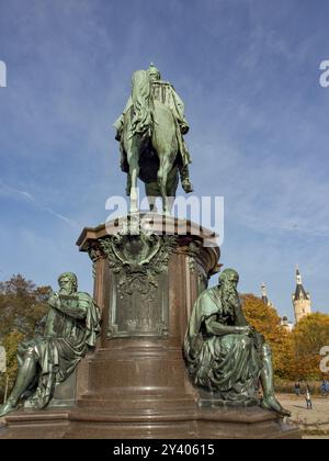 Reiterdenkmal flankiert von zwei sitzenden Statuen vor herbstlichen Bäumen und blauem Himmel, Schwerin, Mecklenburg, Deutschland, Europa Stockfoto