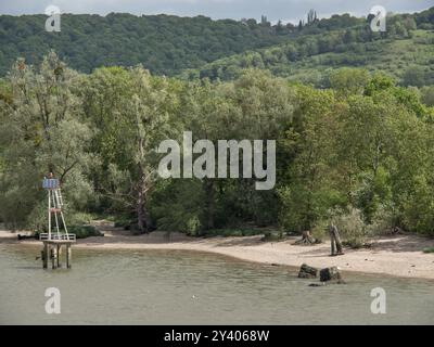 Kleiner Leuchtturm und Sandstrand am Flussufer, umgeben von dichtem Wald und grünen Hügeln, rouen, ITS, frankreich Stockfoto