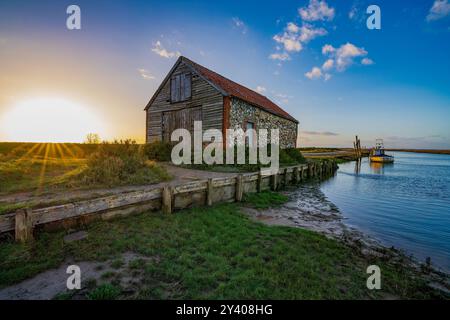 Die alte Kohlescheune und der Quay am Thornham Old Harbour, während Sonnenuntergang. Thornham Norfolk, England, Großbritannien Stockfoto