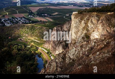 15.09.2024 - Licht und Schattenspiel: Der Rotenfels mit Bastei sowie die Bahnstrecke im Tal werden von den Sonnenstrahlen am Morgen in warmes Licht taucht, während die nahe und Wälder im Schatten liegen. Der Rotenfels 327 m mit seiner sanften Gipfelhochfläche hat seinen Namen von der auffallenden rötlichen Südwestwand, mit der er zur nahe abstürzt. Die Wandflucht ist etwa 1200 Meter lang und etwa 200 Meter hoch, sie gilt als höchste Felswand zwischen den Alpen und Skandinavien. Der Großteil des Rotenfels liegt auf dem Gebiet der Gemeinde Traisen. Unterhalb des Rotenfels, an der nahe, Verlauf Stockfoto