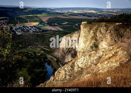 15.09.2024: Licht und Schattenspiel: Der Rotenfels mit Bastei werden von den Sonnenstrahlen am Morgen in warmes Licht taucht, während die nahe und die Bahnstrecke im Tal im Schatten liegen. Der Rotenfels 327 m mit seiner sanften Gipfelhochfläche hat seinen Namen von der auffallenden rötlichen Südwestwand, mit der er zur nahe abstürzt. Die Wandflucht ist etwa 1200 Meter lang und etwa 200 Meter hoch, sie gilt als höchste Felswand zwischen den Alpen und Skandinavien. Der Großteil des Rotenfels liegt auf dem Gebiet der Gemeinde Traisen. Unterhalb des Rotenfels, an der nahe, verlaufen die Landes Stockfoto