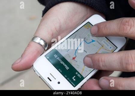 Nahaufnahme eines Mannes, der ein iphone hält und google Maps verwendet, um sich in folgenden Richtungen zu bewegen Stockfoto