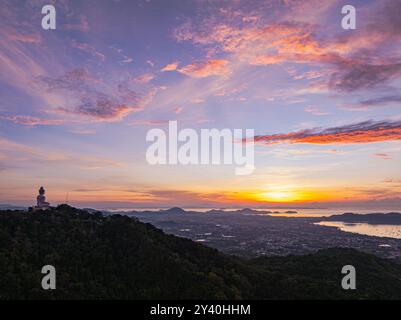 Arial Blick atemberaubender Sonnenaufgang über Phuket Big Buddha auf dem Berg. Ein atemberaubender Panoramablick auf einen lebendigen Sonnenaufgang, der warme Farbtöne über die Küste wirft Stockfoto