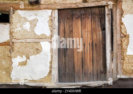 Alte Holztür an der Wand eines alten Hauses im Dorf Stockfoto