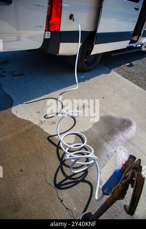 Mit einem sauberen, chemikalienfreien Schlauch einen Wassertank eines Mercedes Benz Sprinter Wohnmobil in Naches, Washington, füllen. USA Stockfoto