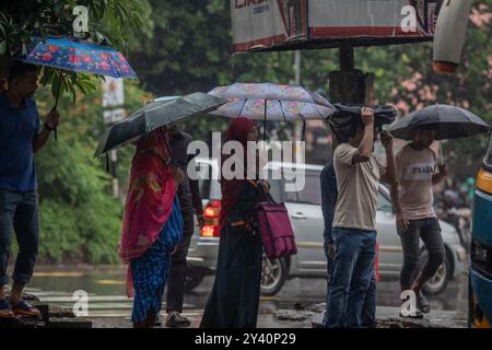 Dhaka, Bangladesch. September 2024. Eine Gruppe von Personen, die an einem regnerischen Tag in Dhaka bei der Überquerung der Straße Regenschirme halten (Credit Image: © Sazzad Hossain/SOPA images via ZUMA Press Wire), NUR REDAKTIONELLE VERWENDUNG! Nicht für kommerzielle ZWECKE! Quelle: ZUMA Press, Inc./Alamy Live News Stockfoto