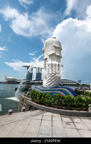 Im Hintergrund befindet sich das Marina Bay Sands Hotel gegenüber der Marina Bay in Singapur. Der Weißwasserbrunnen ist der Merlion, eine mythische Kreatur mit Th Stockfoto