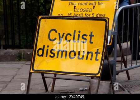 Gelbes Warnschild, das Radfahrer anweist, während Bauarbeiten im Bad uk von ihrem Fahrrad zu steigen Stockfoto