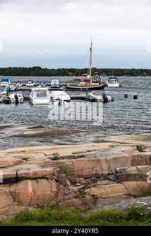 Oregrund, Uppland - Schweden - 30 07 2019 Blick auf den grünen graas, Felsen, das Meer und ein paar kleine Freizeitschiffe an der Ostsee Stockfoto