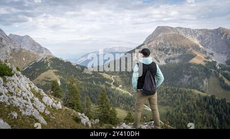 Mann genießt Gipfelaussichten auf Berglandschaften während des bewölkten Tages, Deutschland Stockfoto