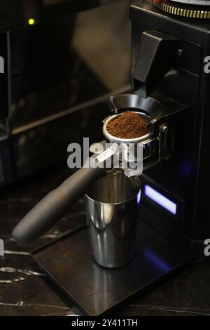 Frisch gemahlene Kaffeebohnen in einem Portafilter bereit für die Zubereitung von Espresso. Stockfoto