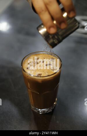 Ein erfrischender Eiskaffee mit Kakaopulver, perfekt für einen heißen Tag Stockfoto