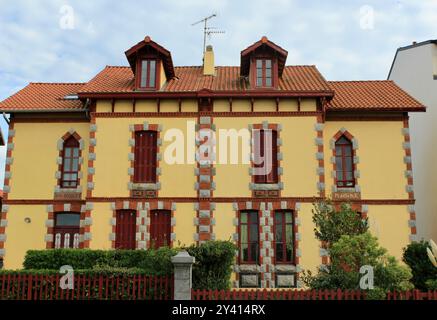 Traditionelles europäisches Haus mit symmetrischer Architektur und markanter Ziegelkonstruktion in Hendaye, Frankreich Stockfoto