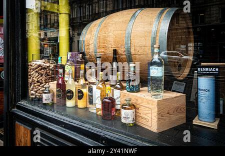 Eine kuratierte Ausstellung zeigt eine Auswahl an Alkoholflaschen, Korken und einem großen Fass in Bordeaux, Frankreich. Stockfoto