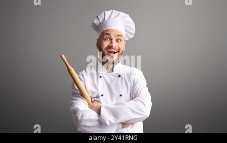 Aufgeregt Hält Baker Rolling Pin Posiert Über Schwarzem Hintergrund, Panorama Stockfoto