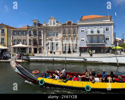 Aveiro, Portugal - 29. Mai 2024: Touristen in einem traditionellen Moliceiro-Boot in einem Kanal in Aveiro, Portugal. Stockfoto