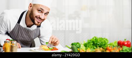 Ein Lächelnder Küchenchef Dekoriert Gebratenes Lachssteak In Der Küche Stockfoto