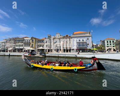 Aveiro, Portugal - 29. Mai 2024: Touristen in einem traditionellen Moliceiro-Boot in einem Kanal in Aveiro, Portugal. Stockfoto