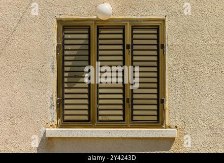 Verschlossenes Fenster in der alten Wand Stockfoto