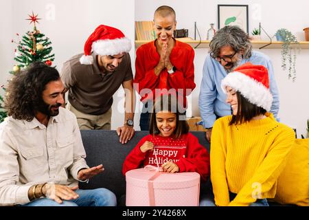 Teenager-Mädchen eröffnete ein weihnachtsgeschenk mit ihrer Familie zu Hause Stockfoto