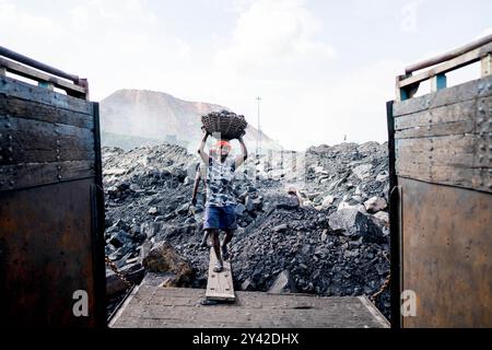 Dhanbad, Jharkhand, Indien. 31. August 2024. Arbeiter laden Kohle auf einen LKW in der Nähe einer Tagebau am Stadtrand von Dhanbad. In Jharia im indischen Bundesstaat Jharkhand leben rund 600.000 Menschen. Es liegt im Herzen des größten Kohlefeldes der Nation. Jharia, das seinen Namen von der Stadt und Region mit dem gleichen Namen erhält, ist auch bekannt für eine schreckliche Rate von Kohleflözbränden, die eine der Hauptquellen der Umweltverschmutzung in der Region und weltweit sind. Kohlendioxid wird durch Kohlebrände in massiver Menge in die Atmosphäre abgegeben. (Kreditbild: © Amarje Stockfoto