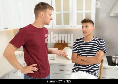 Junge Brüder, die zu Hause in der Küche reden Stockfoto
