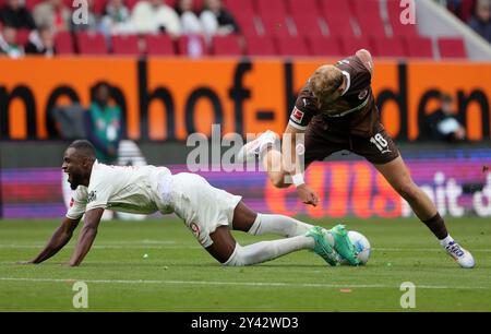 Augsburg, Deutschland. September 2024. Frank Onyeka (L) von Augsburg streitet mit Carlo Boukhalfa von St. Pauli während des Fußball-Spiels der ersten Bundesliga zwischen Augsburg und St. Pauli in Augsburg, Deutschland, 15. September 2024. Quelle: Philippe Ruiz/Xinhua/Alamy Live News Stockfoto