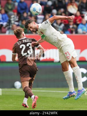 Augsburg, Deutschland. September 2024. Maximilian Bauer (R) von Augsburg streitet mit Philipp Treu von St. Pauli während des ersten Bundesliga-Fußballspiels zwischen Augsburg und St. Pauli am 15. September 2024 in Augsburg. Quelle: Philippe Ruiz/Xinhua/Alamy Live News Stockfoto