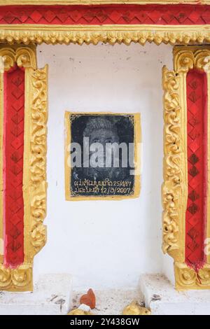 Blick auf ein schwarzes Granitporträt, das ein Grab im Wat Chanthaboury Buddhistischen Tempel in Vientiane, Laos, graviert. Stockfoto