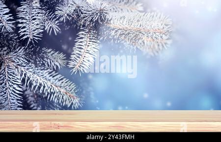 Weihnachtshintergrund. Leere Holztischplatte vor sonnigem Winterwald. Holzterrassenfußboden und Tannenzweig mit Frost bedeckt. Feiertag Xma Stockfoto