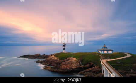 Ein Foto von einem Sonnenuntergang im 16:9-Format am Leuchtturm „Faro Illa Pancha“, der sich auf der Insel Pancha in der Nähe der Stadt Ribadeo in Galicien befindet; Stockfoto