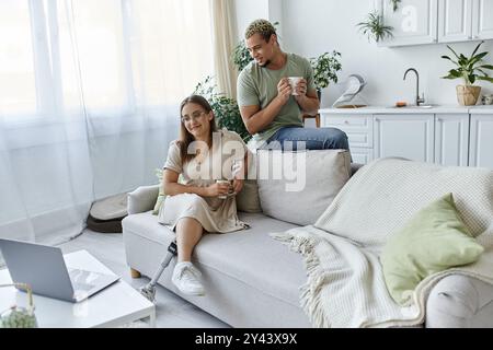 Zwei Freunde teilen sich Lachen und Getränke in einem hellen, modernen Wohnraum. Stockfoto